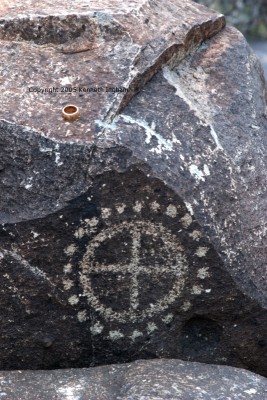 petroglyph of a + in a circle surrounded by dots
